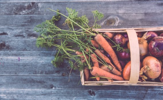 carrots and onions in brown wicker basket