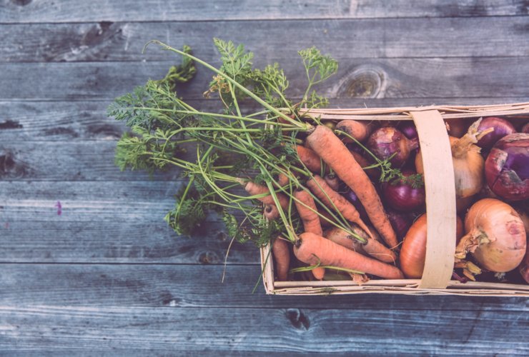 carrots and onions in brown wicker basket