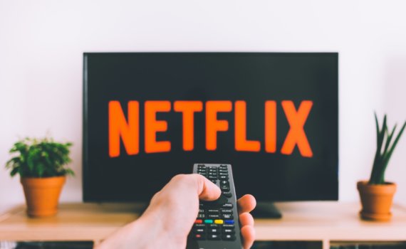person holding remote pointing at TV