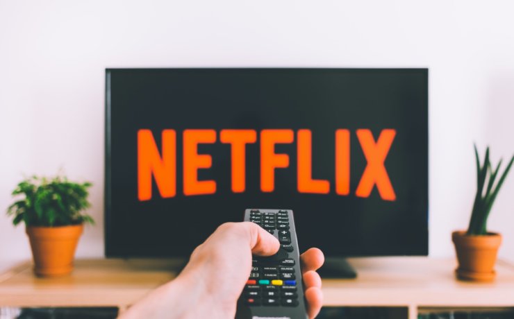 person holding remote pointing at TV