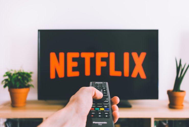 person holding remote pointing at TV