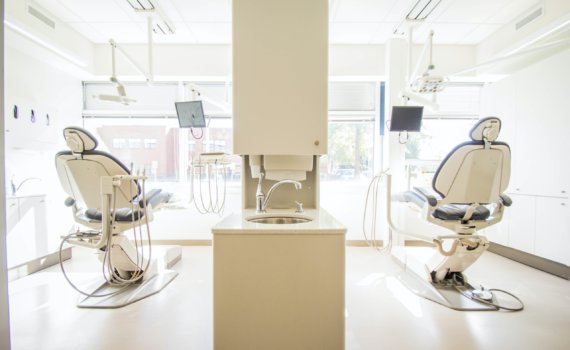 two white dentist chairs inside white painted room