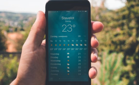 person holding iPhone 7 displaying 23 degree celcius