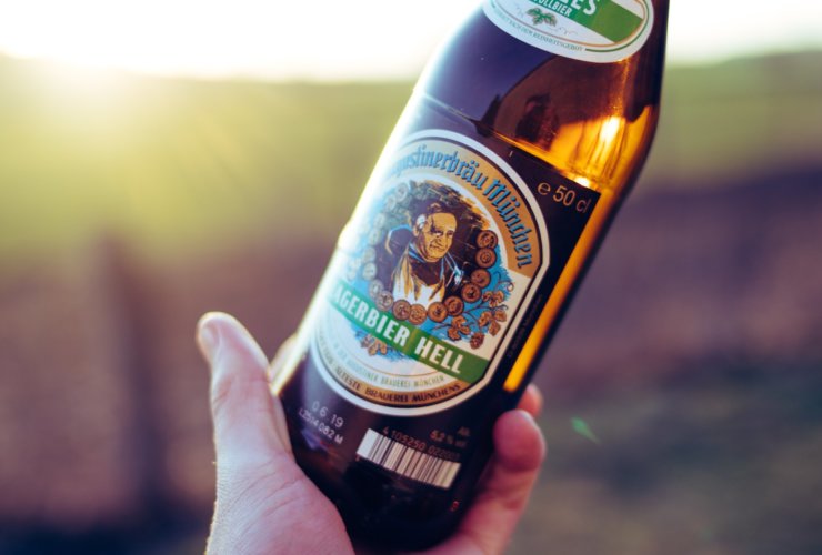 person holding new castle brown ale bottle