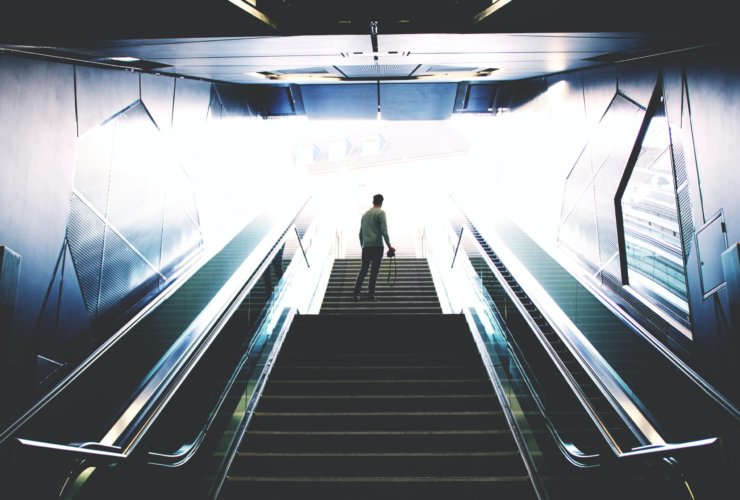 man standing on escalator