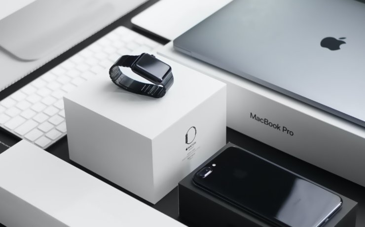 space black case Apple Watch, silver MacBook Pro, jet black iPhone 7 Plus, and silver iMac with corresponding boxes